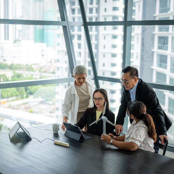 Business people surrounding a tablet and discussing sustainable energy